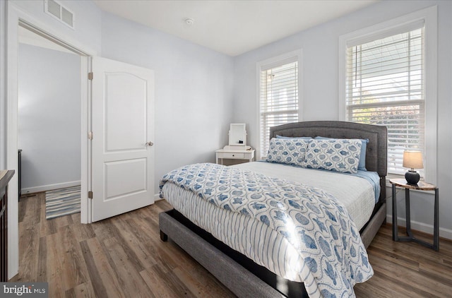 bedroom with dark hardwood / wood-style flooring