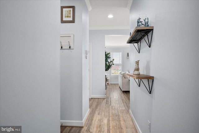 hall featuring ornamental molding and light hardwood / wood-style flooring