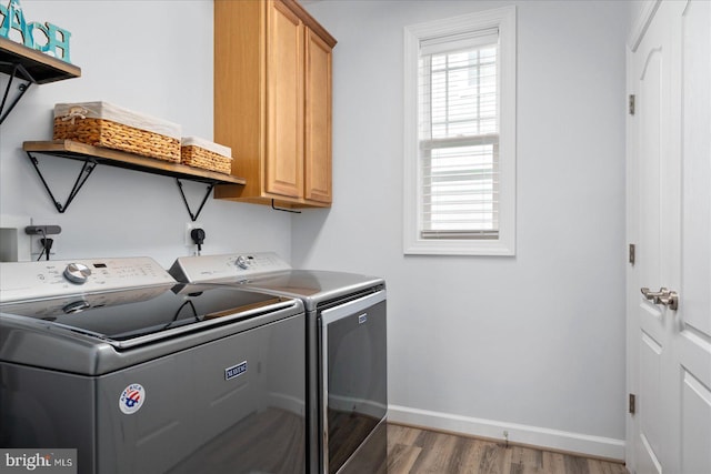 laundry area featuring cabinets, light wood-type flooring, and washer and clothes dryer