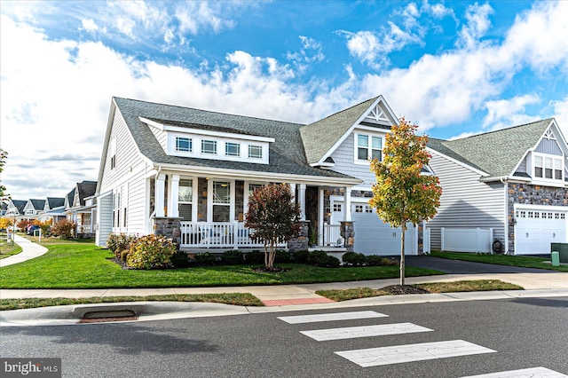 view of front of property featuring a front lawn, a porch, and a garage