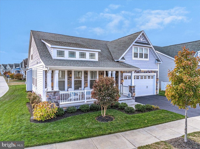 view of front facade with covered porch, a garage, and a front yard