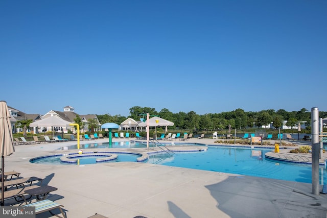 view of swimming pool featuring a community hot tub and a patio