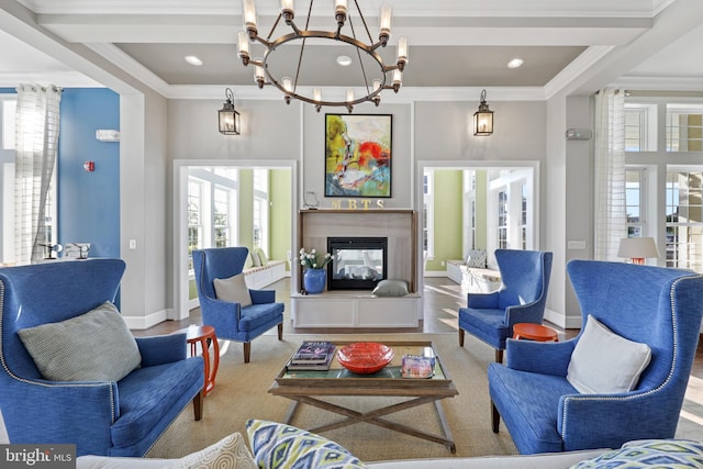 living room with an inviting chandelier, crown molding, and a healthy amount of sunlight