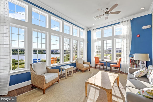 sunroom / solarium featuring a water view, plenty of natural light, and ceiling fan