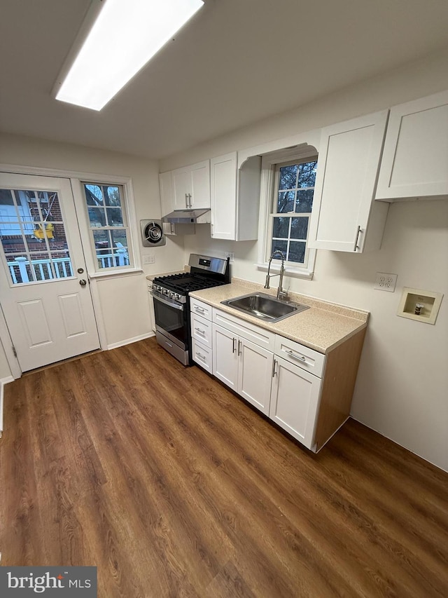 kitchen featuring gas stove, sink, white cabinets, and dark hardwood / wood-style floors