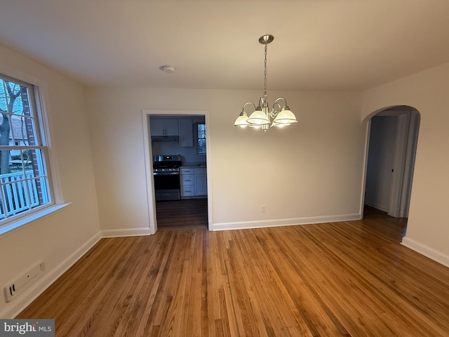 unfurnished dining area with hardwood / wood-style flooring and an inviting chandelier