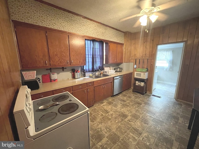 kitchen with white electric range oven, a textured ceiling, sink, dishwasher, and wood walls