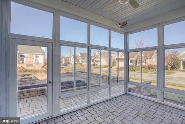 unfurnished sunroom with plenty of natural light and ceiling fan