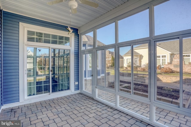 unfurnished sunroom featuring ceiling fan