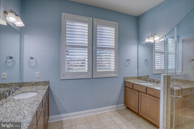 bathroom with tile patterned floors, a shower with door, and vanity