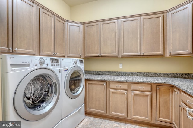 washroom featuring washer and clothes dryer and cabinets