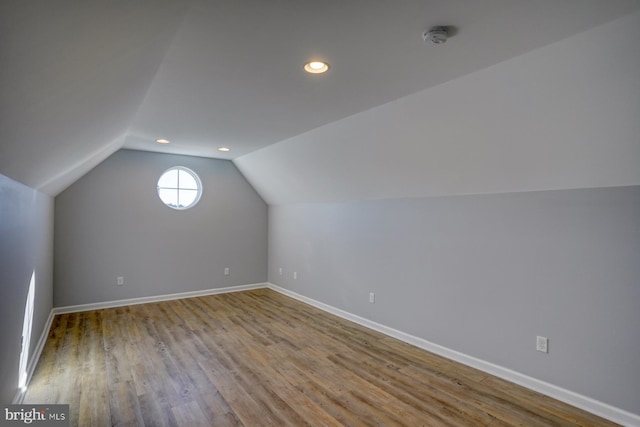 additional living space featuring light wood-type flooring and vaulted ceiling