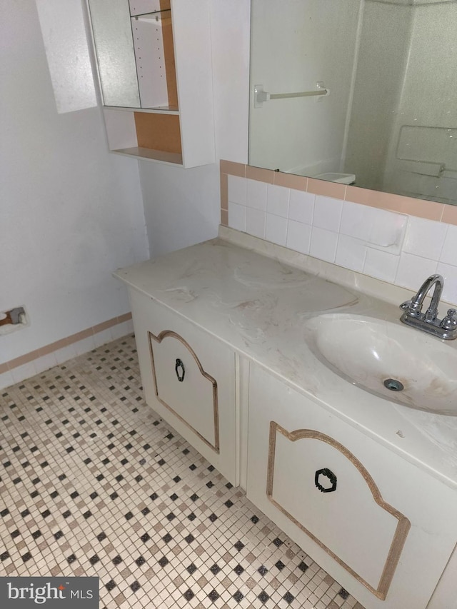 bathroom featuring vanity, backsplash, and tile patterned flooring