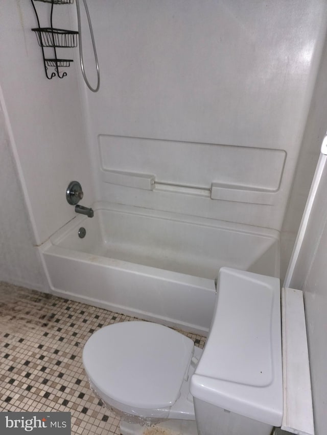 bathroom with tile patterned flooring, tub / shower combination, and toilet