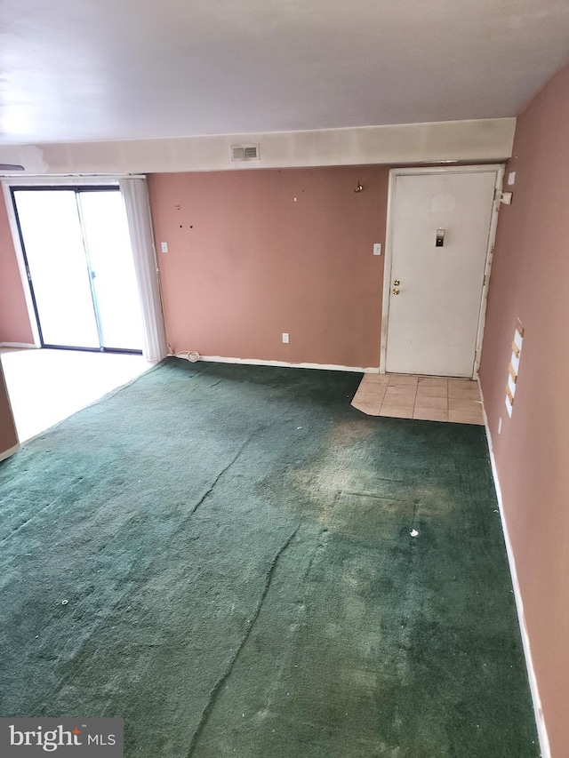 foyer entrance featuring dark colored carpet