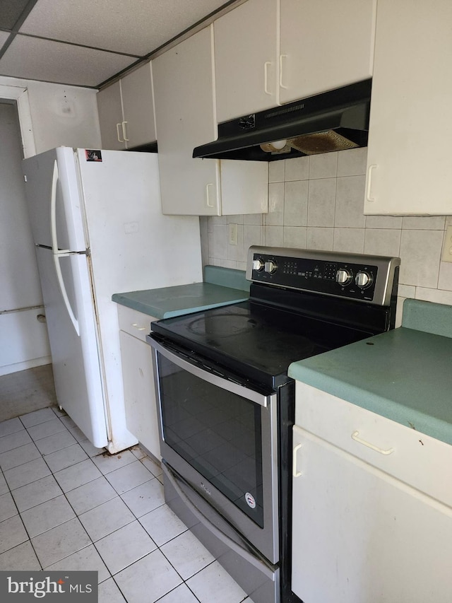 kitchen with backsplash, electric stove, white cabinetry, and light tile patterned floors