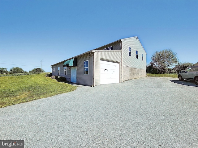 view of side of property featuring a garage and a lawn