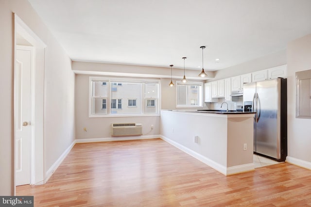 kitchen with a wall mounted air conditioner, white cabinetry, hanging light fixtures, kitchen peninsula, and stainless steel refrigerator with ice dispenser