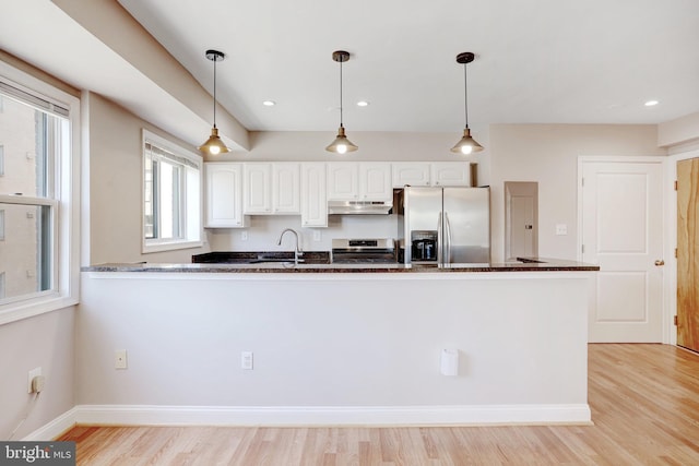 kitchen with white cabinetry, decorative light fixtures, dark stone counters, kitchen peninsula, and stainless steel appliances