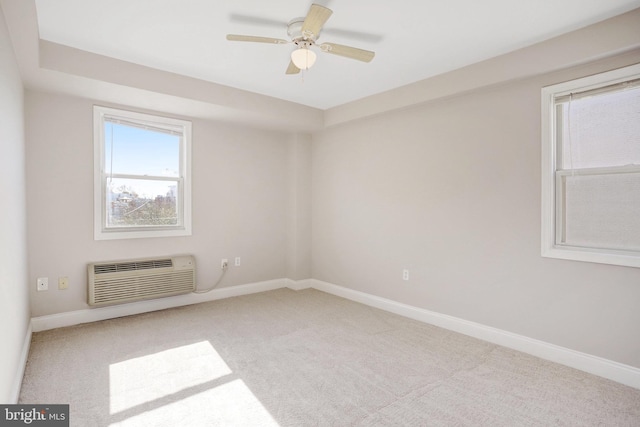 carpeted empty room with ceiling fan and a wall unit AC