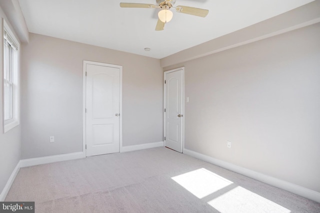 unfurnished bedroom featuring light colored carpet and ceiling fan