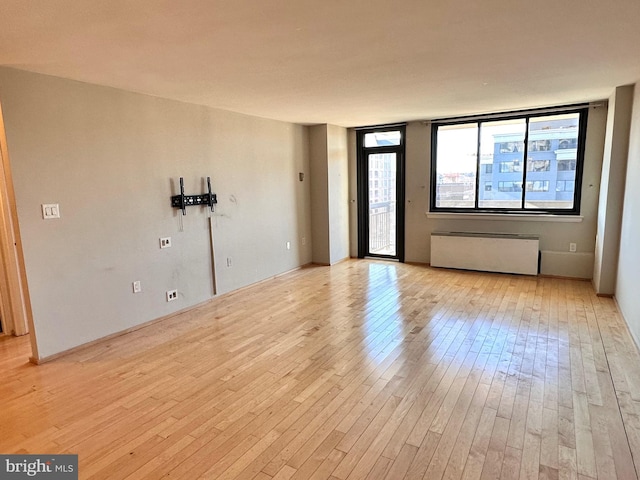 empty room with radiator and light wood-type flooring