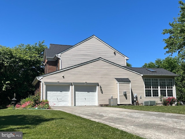 view of side of home featuring a yard, cooling unit, and a garage