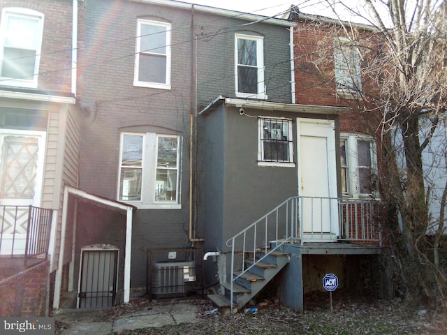 back of property featuring brick siding and central AC unit