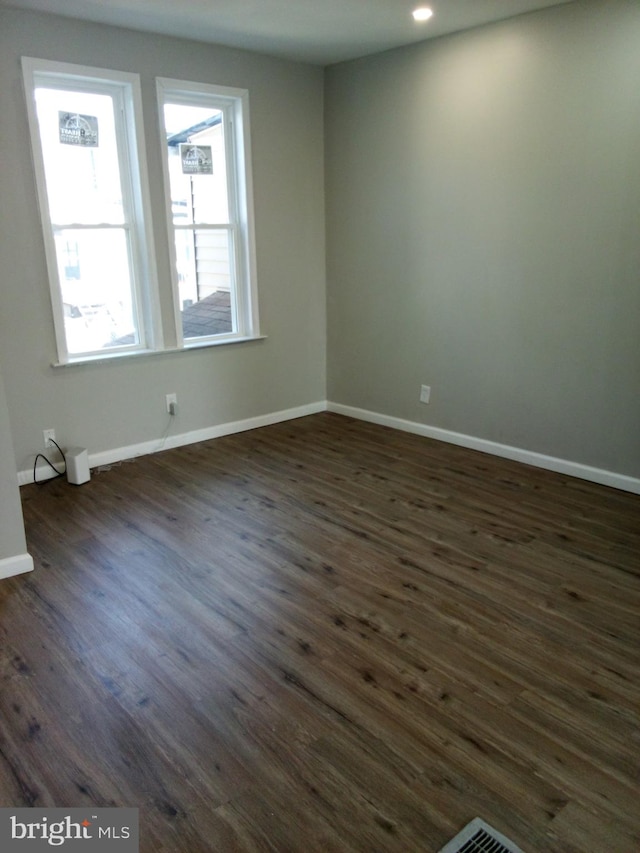 unfurnished room with dark wood-type flooring, recessed lighting, and baseboards