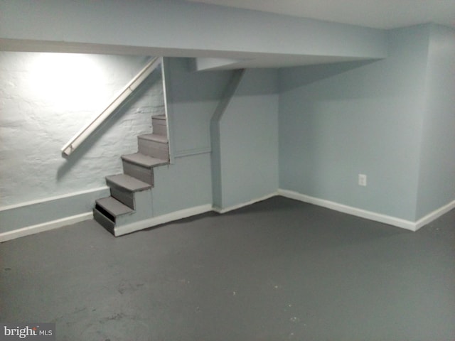 finished basement featuring stairway and baseboards