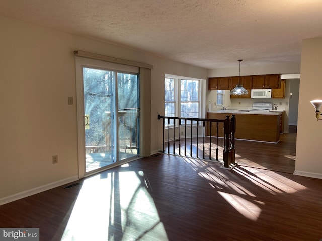 interior space featuring a textured ceiling and dark hardwood / wood-style floors