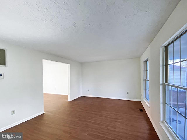 empty room featuring dark hardwood / wood-style flooring and a textured ceiling