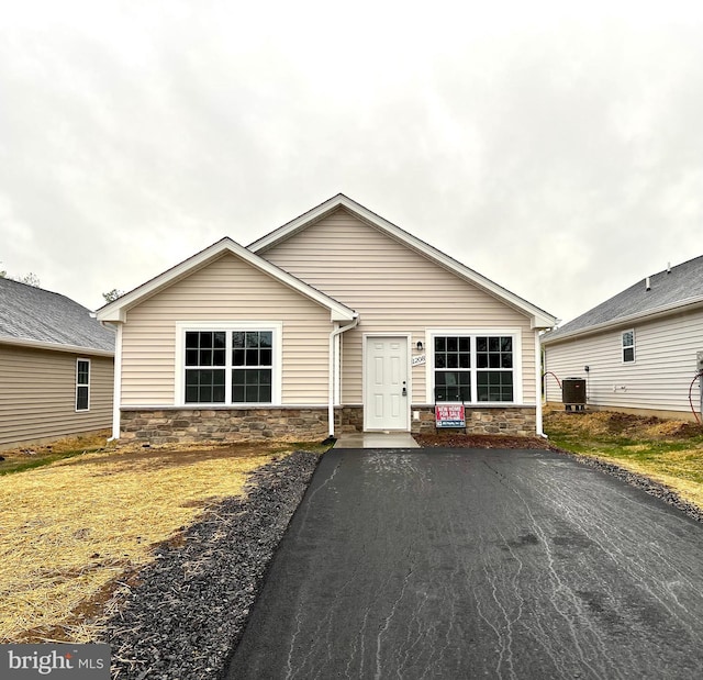 view of front of home featuring central air condition unit and stone siding