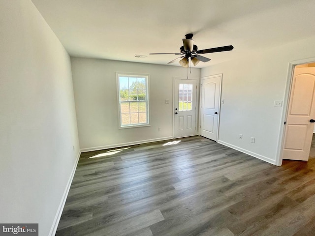 interior space featuring visible vents, baseboards, dark wood finished floors, and a ceiling fan