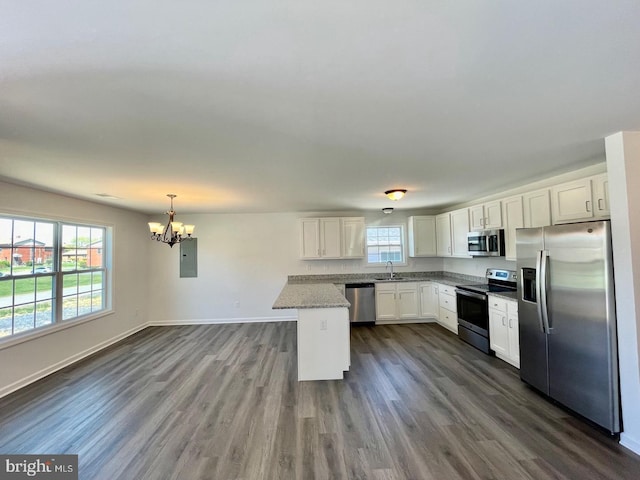 kitchen with a center island, decorative light fixtures, stainless steel appliances, white cabinets, and a sink