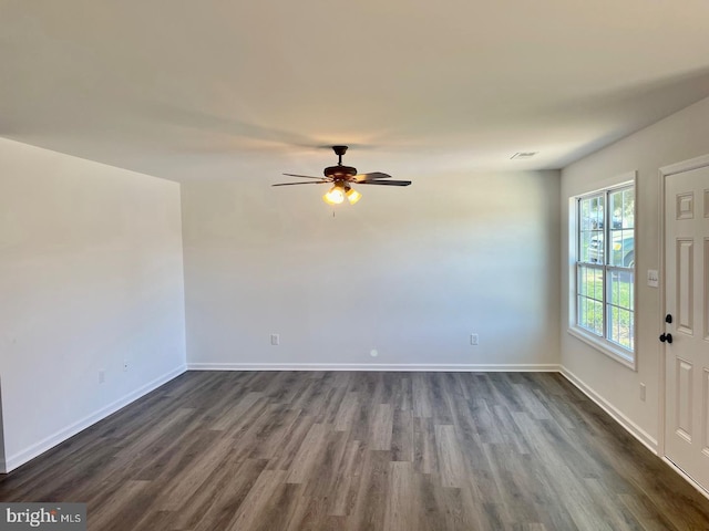 empty room featuring ceiling fan, dark wood-type flooring, and baseboards