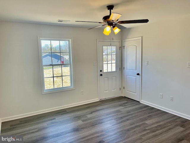 interior space featuring a wealth of natural light, dark wood-style flooring, visible vents, and baseboards