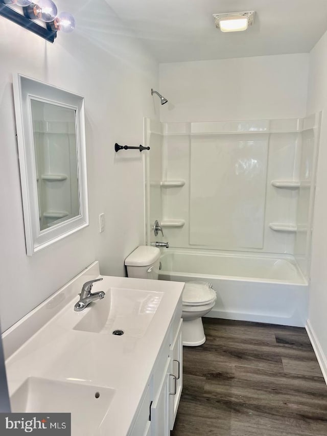 full bathroom with tub / shower combination, vanity, toilet, and wood finished floors