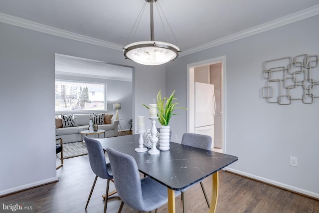 dining space featuring crown molding and dark hardwood / wood-style flooring