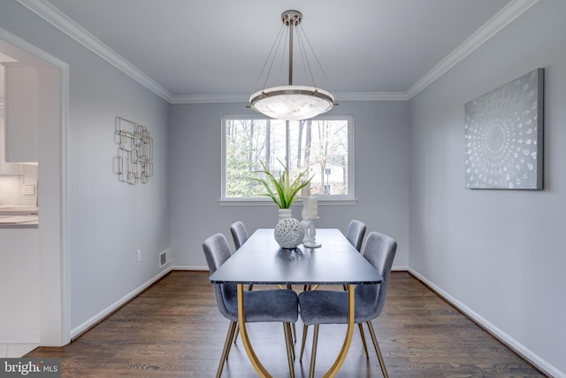 dining area featuring crown molding and dark wood-type flooring