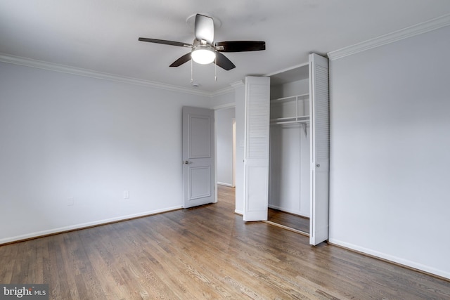 unfurnished bedroom featuring hardwood / wood-style floors, ornamental molding, a closet, and ceiling fan