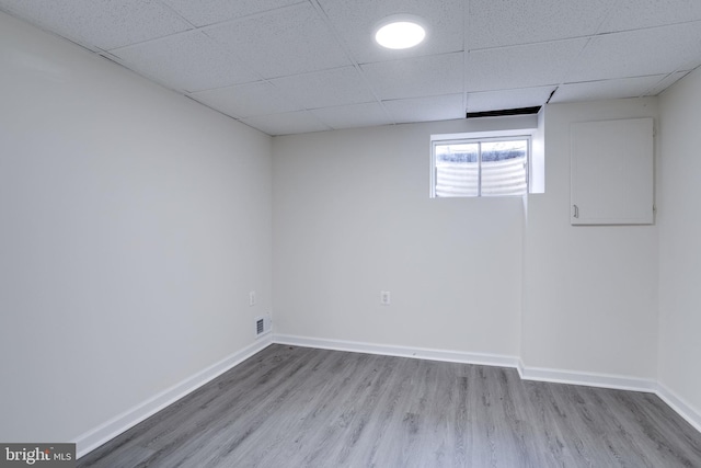 unfurnished room featuring wood-type flooring and a paneled ceiling