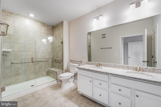 bathroom featuring tile patterned floors, vanity, toilet, and an enclosed shower