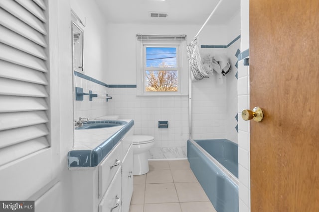 full bathroom with tile patterned flooring, shower / bath combination with curtain, toilet, vanity, and tile walls