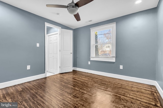 unfurnished bedroom with dark hardwood / wood-style flooring, a closet, and ceiling fan