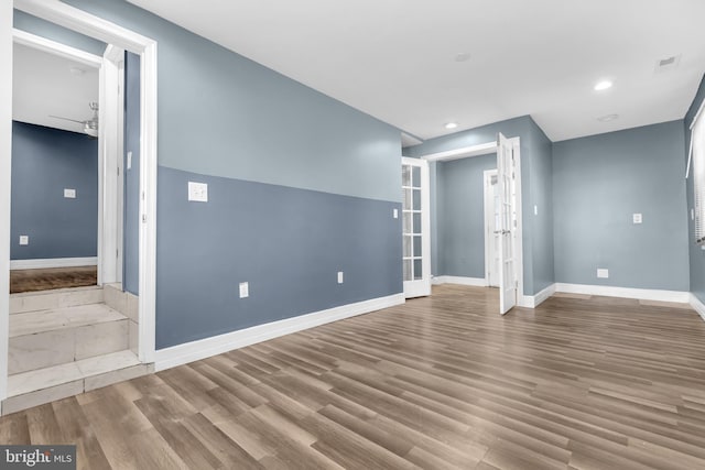 unfurnished living room featuring hardwood / wood-style floors and french doors