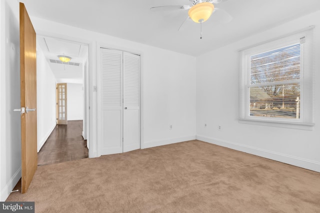 unfurnished bedroom with carpet floors, a closet, and ceiling fan