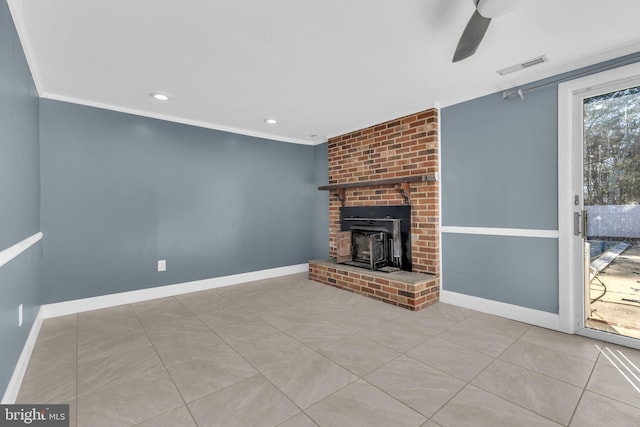 unfurnished living room with light tile patterned floors, a wood stove, ceiling fan, and ornamental molding