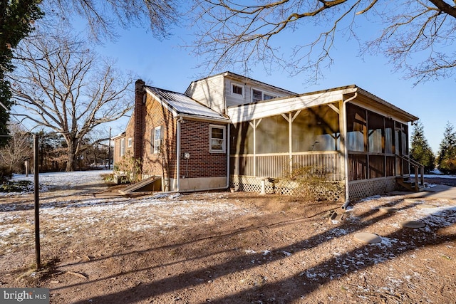 view of snowy exterior featuring a sunroom