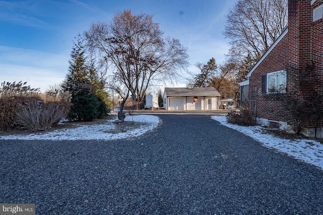 snowy yard featuring an outbuilding and a garage